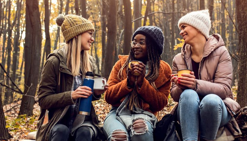 3 Vrouwen die warme thee drinken in een koud bos.